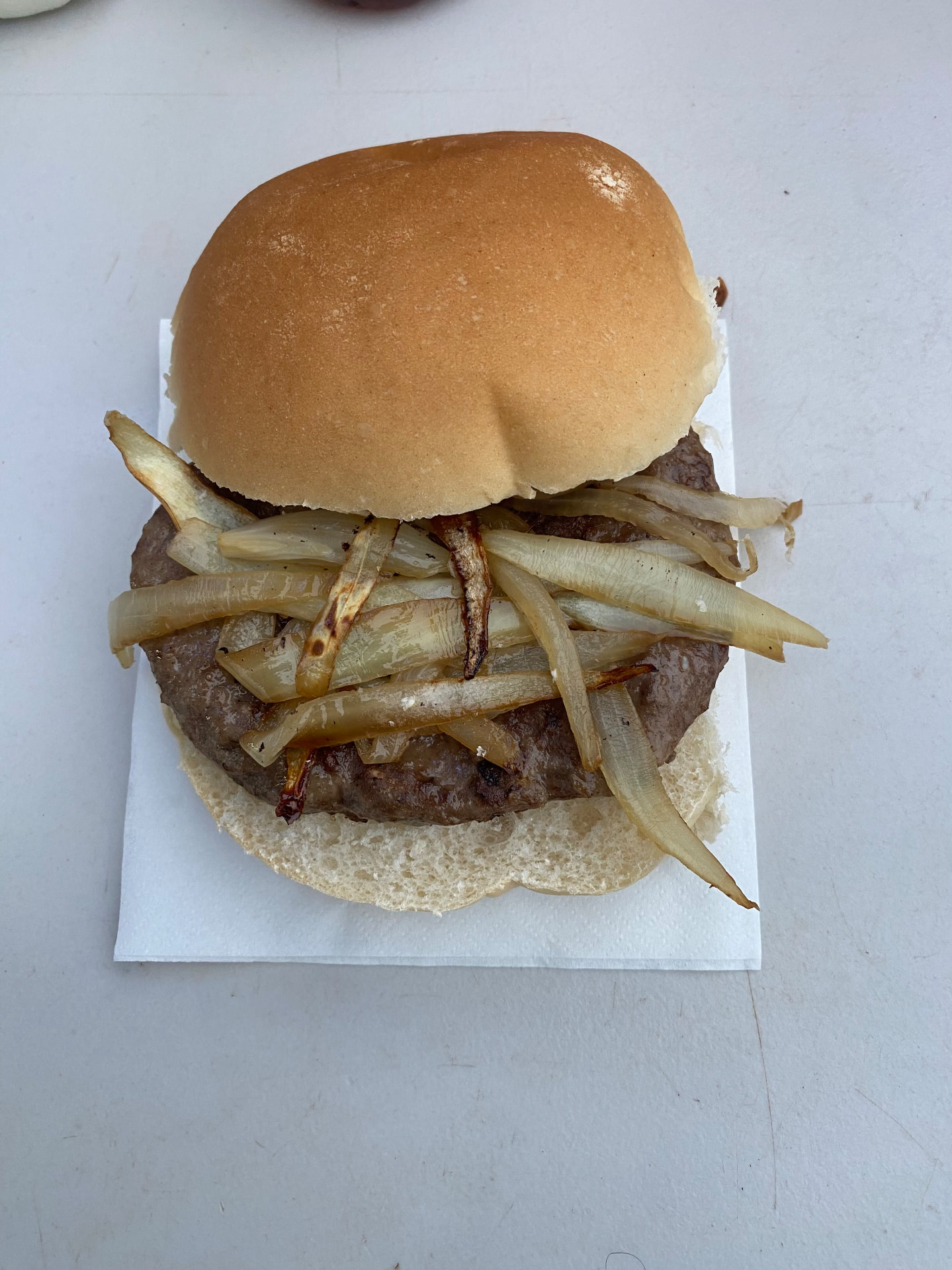 Racing Club Warwick's beef burger opened, showing its patty and fried onions