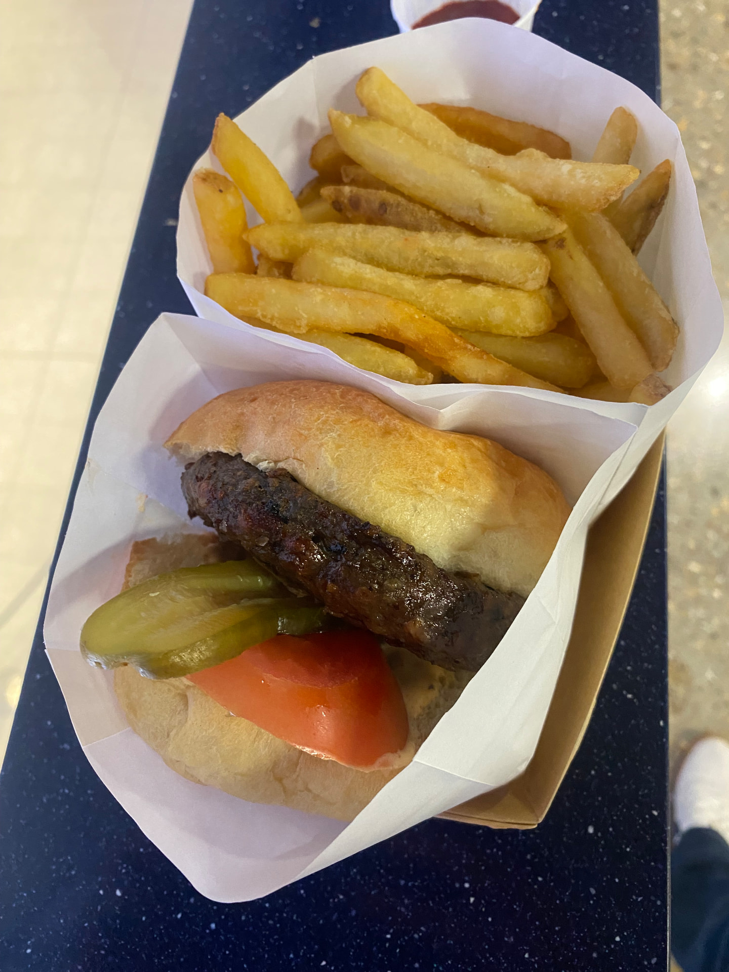 The venison Game Burger closed in its box alongside skin-on fries at the Tottenham Hotspur Stadium